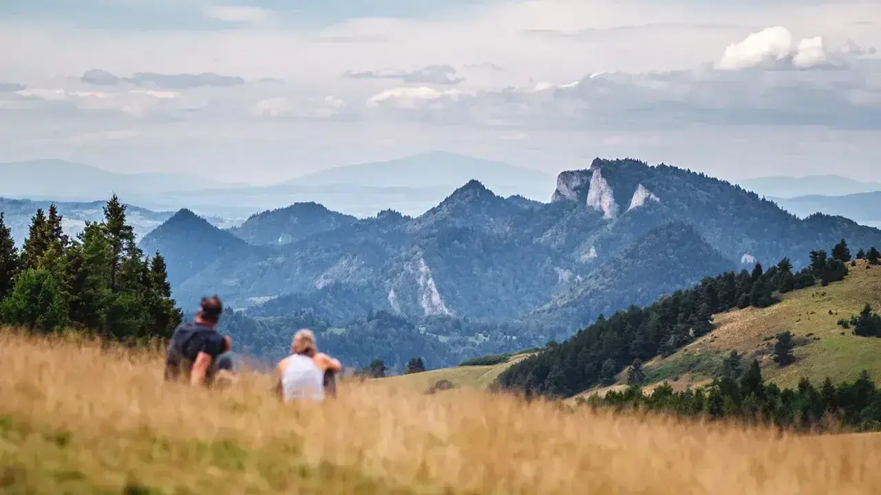Para odpoczywa po szybkim trekkingu, podziwiając malownicze góry.
