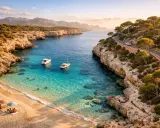 Malownicza zatoka z turkusową wodą, plażą i łodziami. Idealne miejsce, by sprawdzić, co zobaczyć na Palma de Mallorca.