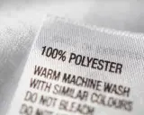 Metka odzieżowa z napisem "100% POLYESTER". Materiał ten, w przeciwieństwie do poliamidu, jest trwały i łatwy w pielęgnacji.