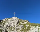 Kamienista trasa na Giewont prowadzi pod górę, gdzie widać krzyż na szczycie.