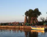 Drewniany pomost na zalewie wiślanym z łodziami i sieciami rybackimi.
