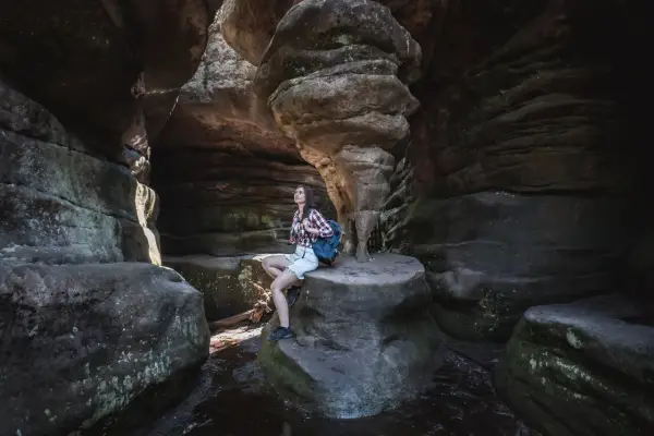 Góry Stołowe: co zobaczyć? Turystka podziwia skalne formacje w wąwozie.
